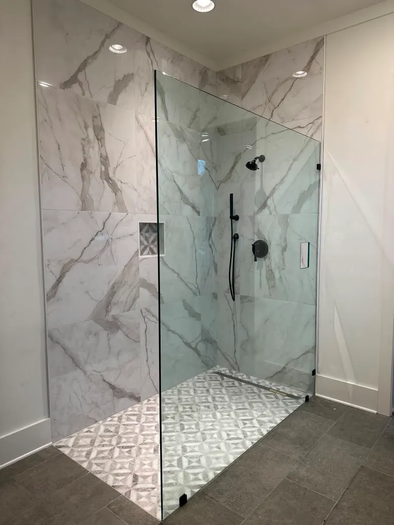 Ducha de marmol con paredes en diagonal y piso de mosaico