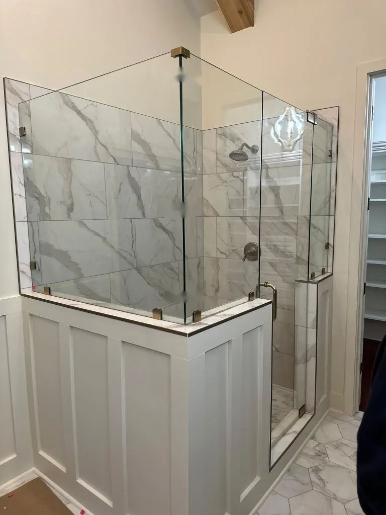 Ducha de marmol sobre un medio muro de boiserie pintado